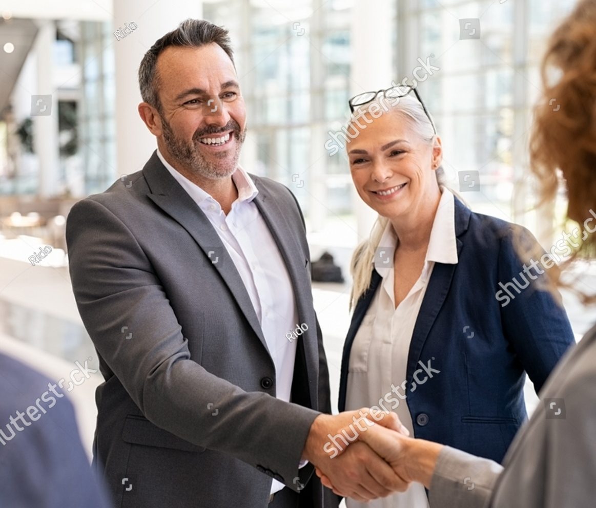 Smiling businessman shaking hands with a businesswoman in a modern office