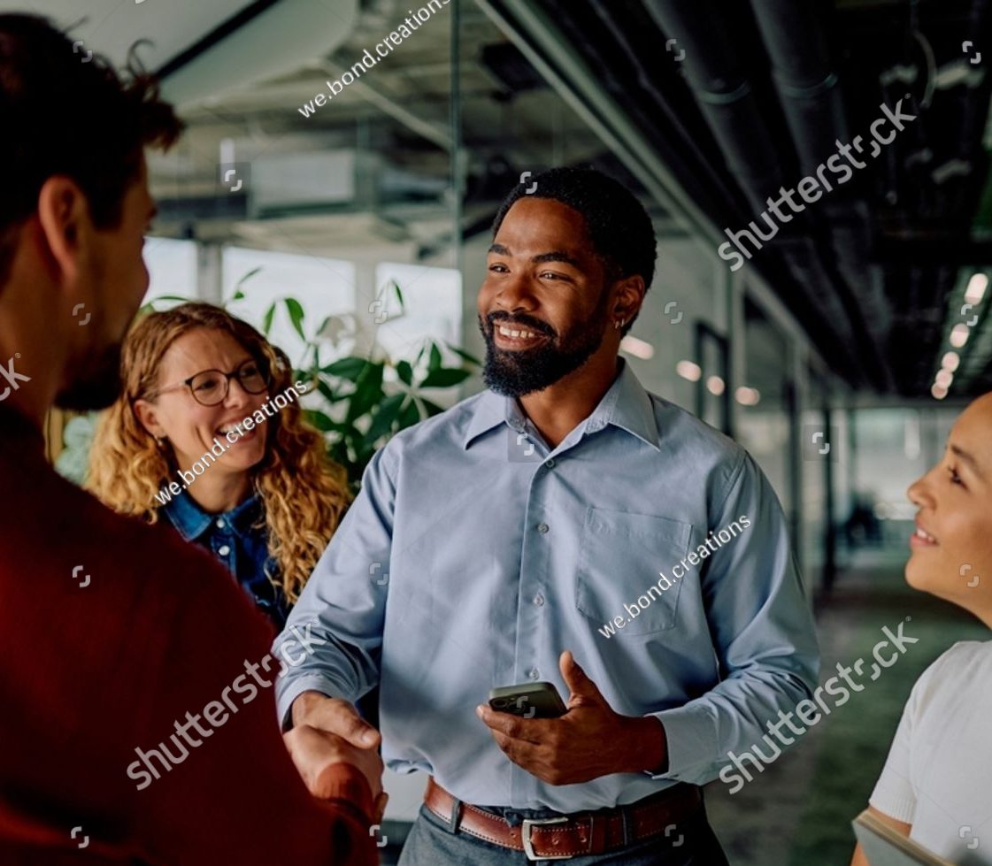 Diverse business team shaking hands in an office hallway