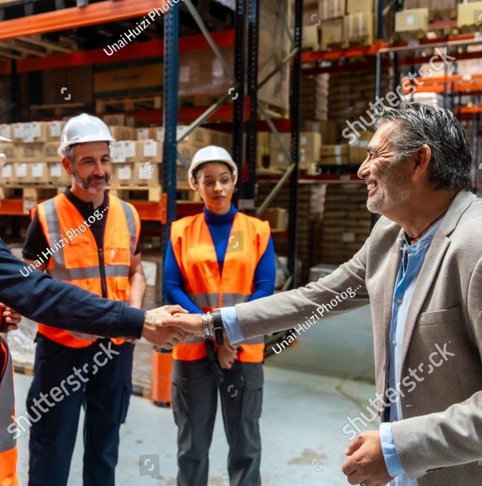Warehouse manager shaking hands with a logistics worker in a hard hat